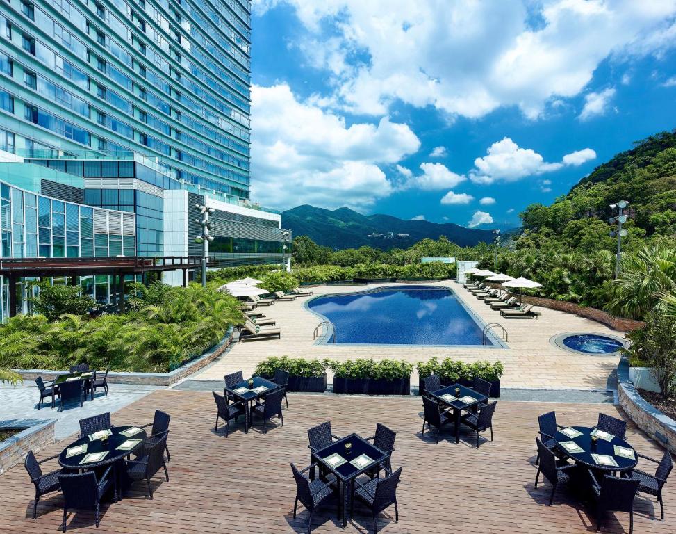 patio z krzesłami, basenem i budynkiem w obiekcie Hyatt Regency Hong Kong, Sha Tin w Hongkongu