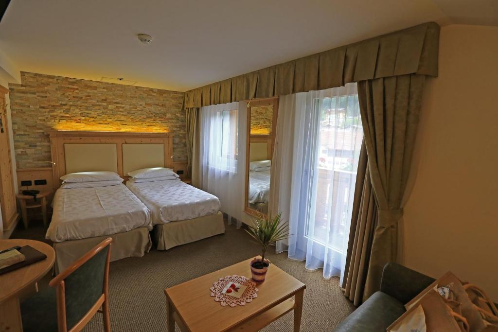 Postel nebo postele na pokoji v ubytování Hotel Ladina