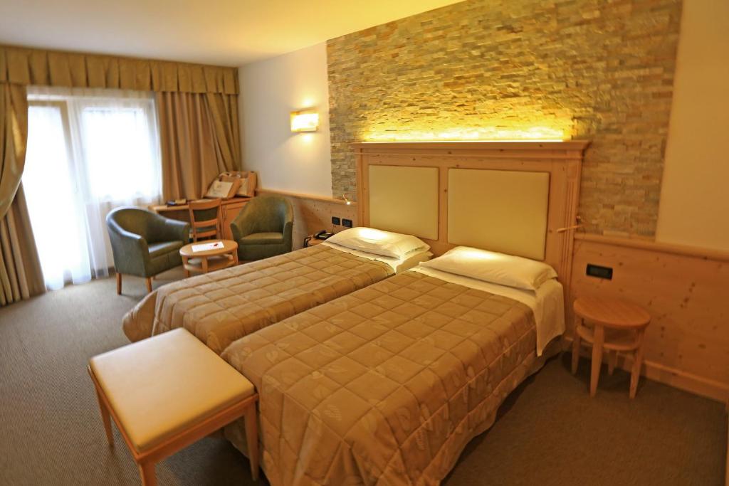 Postel nebo postele na pokoji v ubytování Hotel Ladina