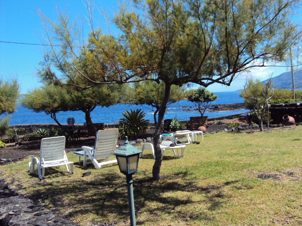 a group of chairs and a tree and a street light at Casa da Baía in Prainha de Baixo