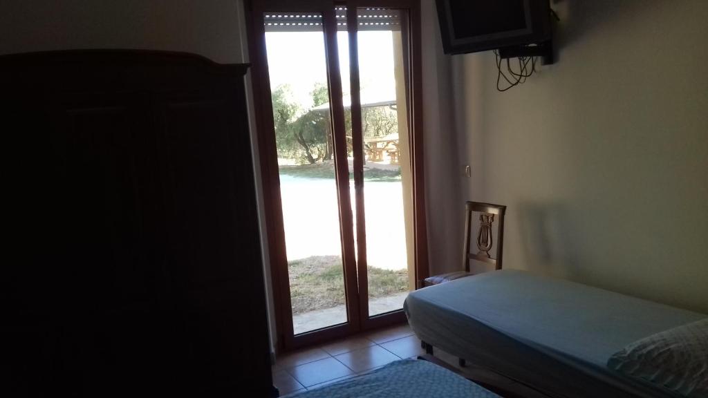 een slaapkamer met een bed en een deur met een raam bij Camping Agriturist Sant'Anna in Castelplanio