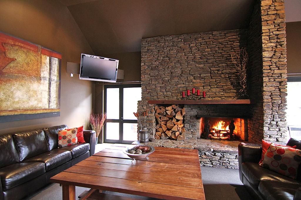 a living room with a couch and a fireplace at Drifters Inn in Hanmer Springs