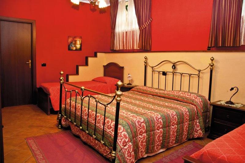 een slaapkamer met een bed met rode muren en een trap bij Aia di Lazzaro Country House in Casalbore