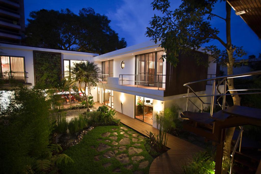 a house with a balcony and a garden at night at La Inmaculada Hotel in Guatemala