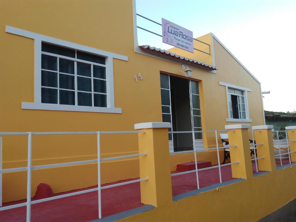 un bâtiment jaune avec un panneau sur son côté dans l'établissement Pousada Lua Rosa, à Piranhas