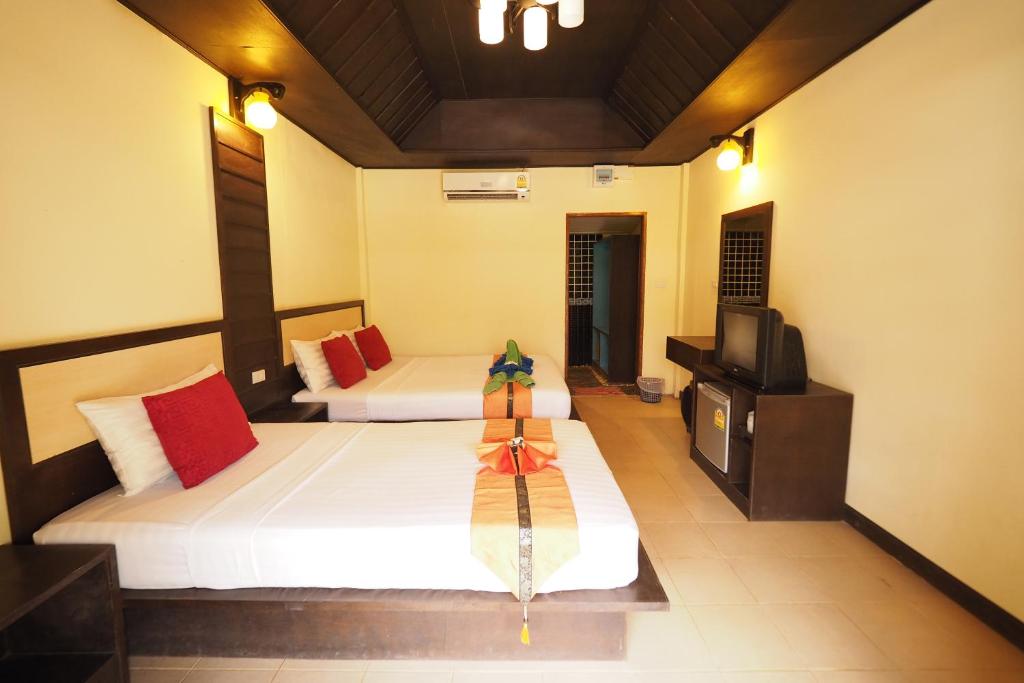 a hotel room with two beds and a television at Lanta Paragon in Ko Lanta
