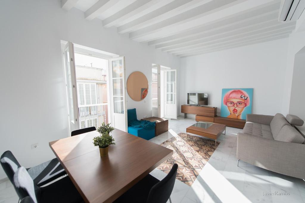 - un salon avec une table et un canapé dans l'établissement Casa Margot Cádiz, à Cadix