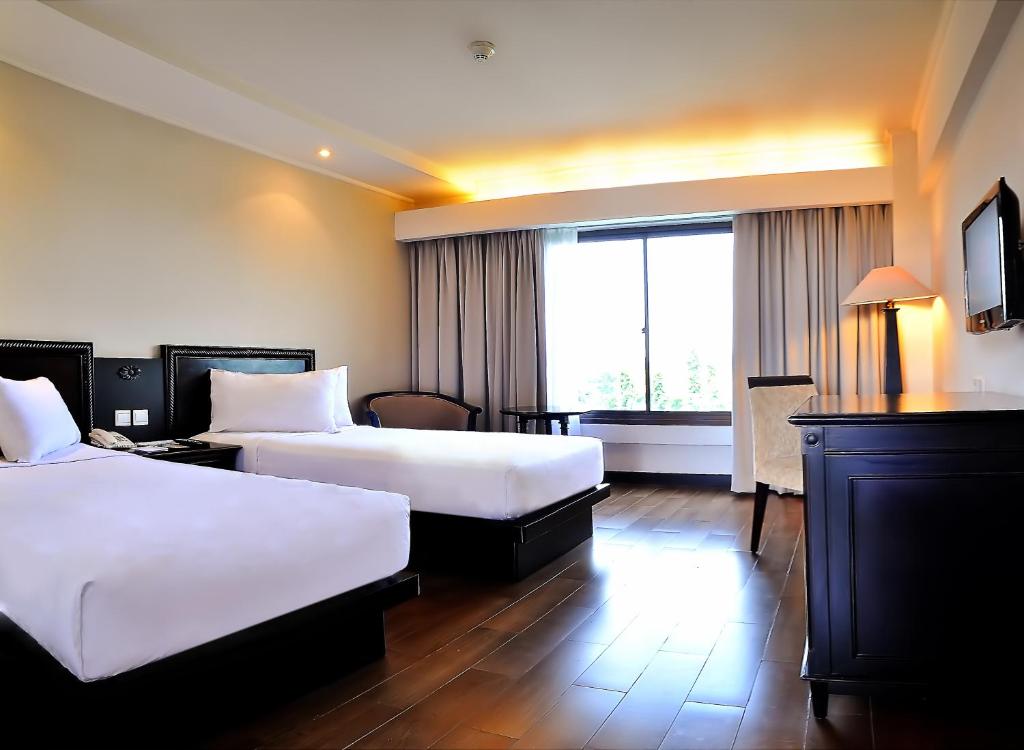 Postel nebo postele na pokoji v ubytování Hotel Santika Cirebon