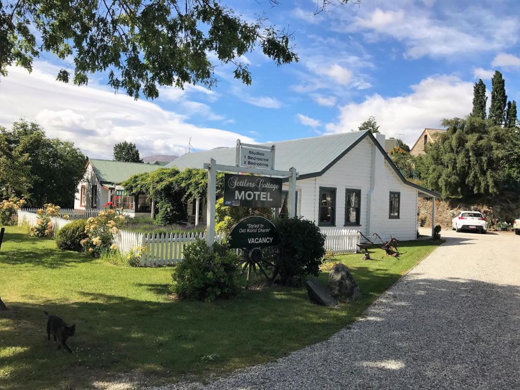 Un motel con gatos caminando delante de él en Settlers Cottage Motel, en Arrowtown