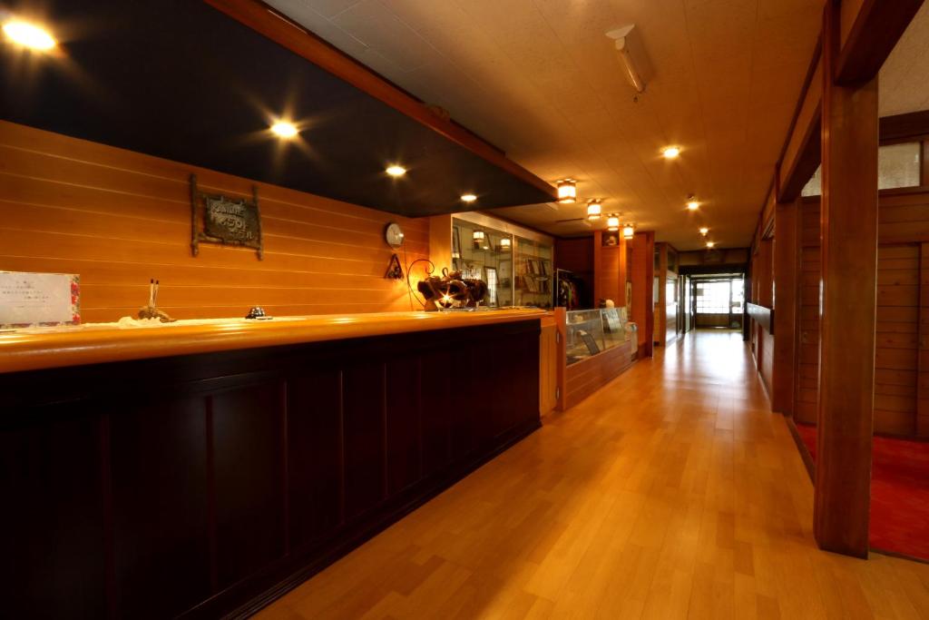 cocina grande con barra y suelo de madera en Kannabe Highland Hotel, en Toyooka
