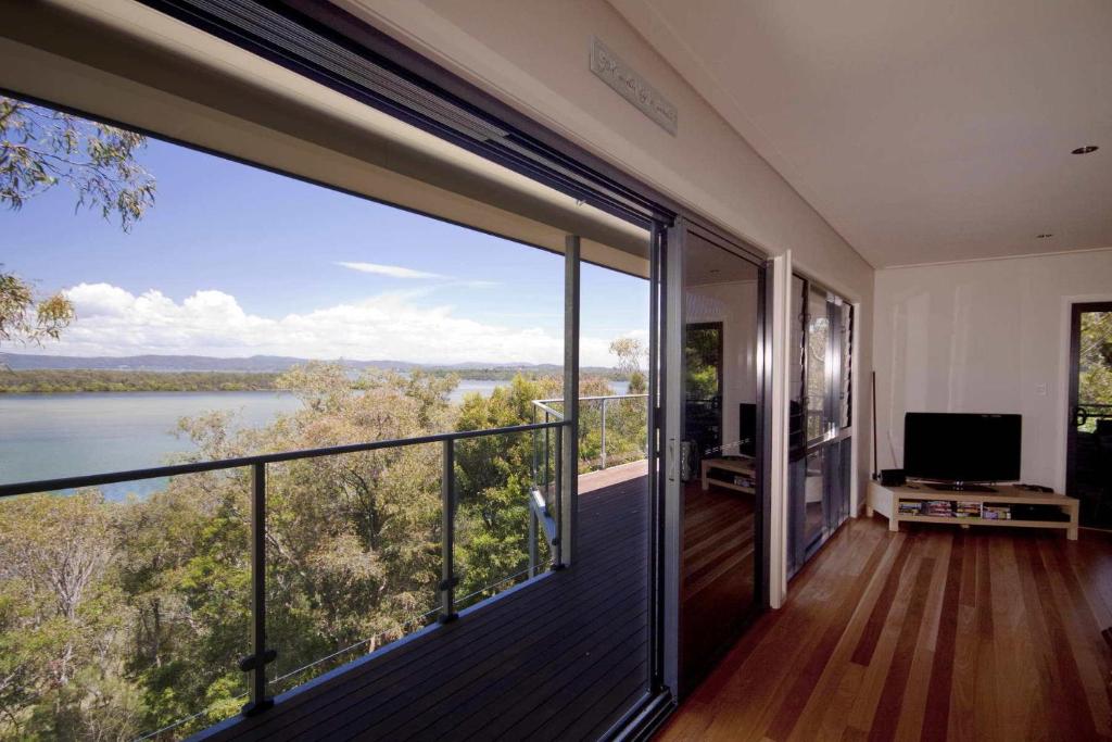 a house with a balcony with a view of the water at Berringar in Forster