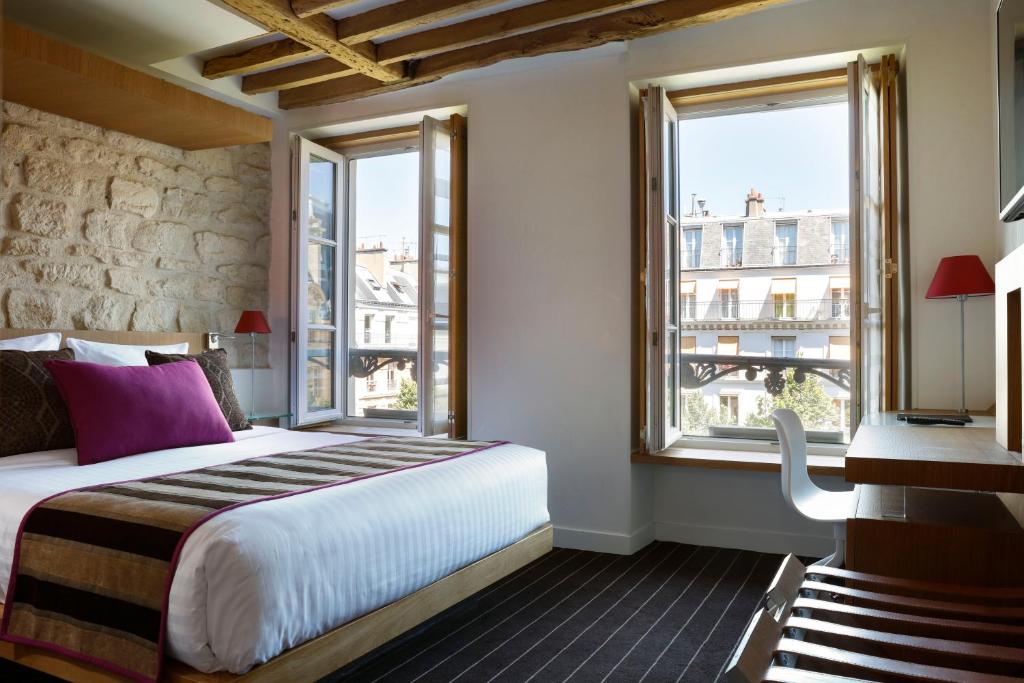 1 dormitorio con 1 cama grande y ventanas en Select Hotel, en París