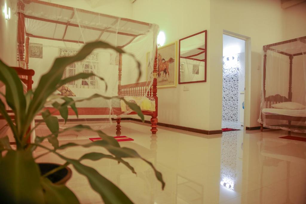 a bedroom with a bed and a plant in the foreground at Anjana Villa in Galle