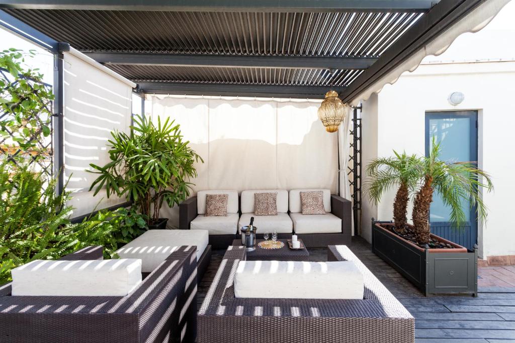 un patio con 2 sofás y una mesa en City Rooftop Paradise - Space Maison Apartments, en Sevilla