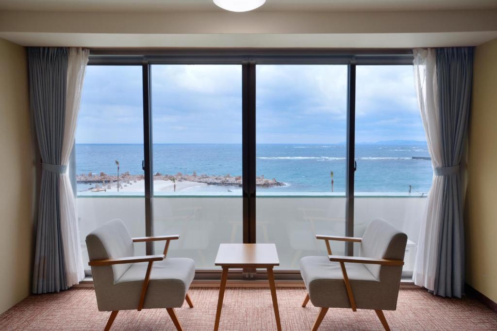 a room with a large window with a view of the ocean at Hotel Sanrakuso in Shirahama