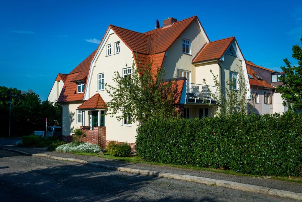 クヴェードリンブルクにあるBellevue Ferienwohnungenの赤屋根の大白屋敷