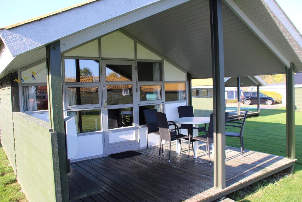 cenador con mesa y sillas en la terraza en First Camp Holbæk Fjord en Holbæk