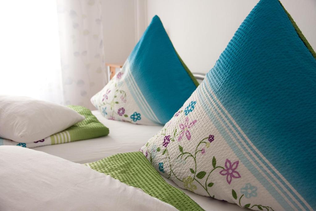 Una cama con dos almohadas azules encima. en Apartments City Room Berlin, en Berlín