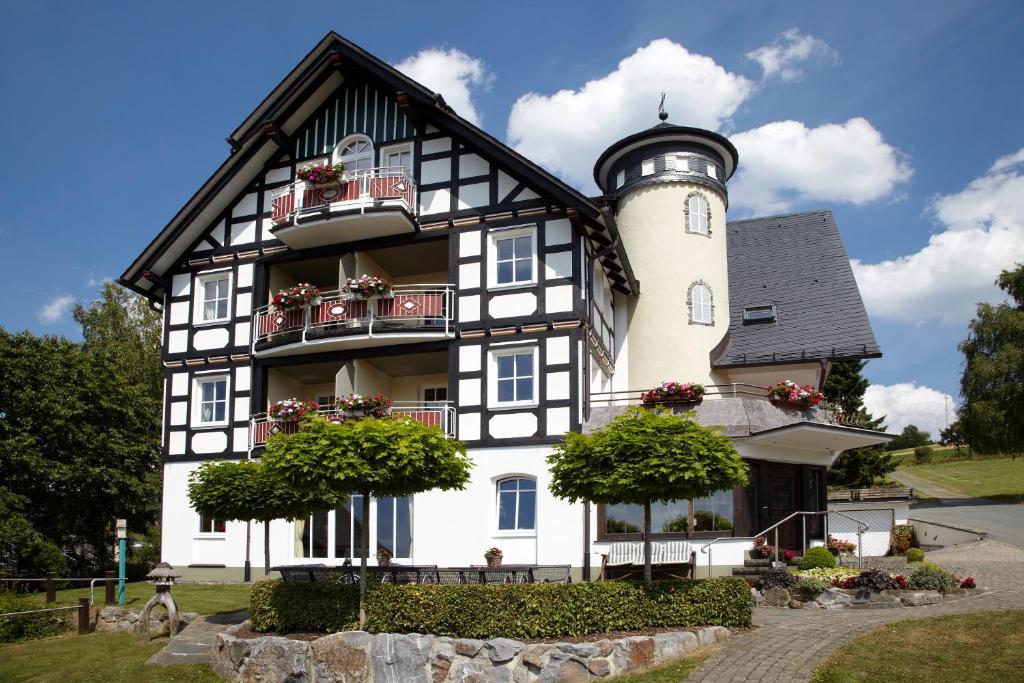 un edificio blanco y negro con un faro en Pension und Ferienwohnung Schütte en Schmallenberg