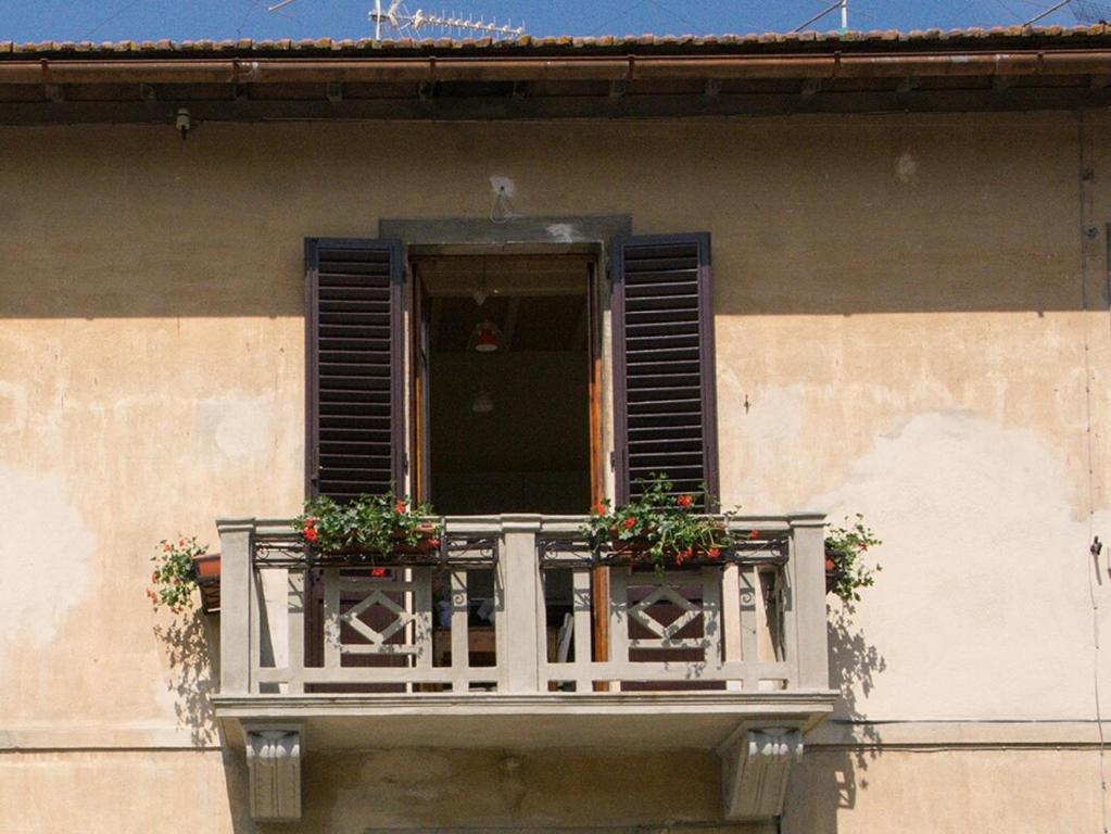une fenêtre avec deux plantes sur un balcon dans l'établissement Il balcone di Rina, à San Gimignano