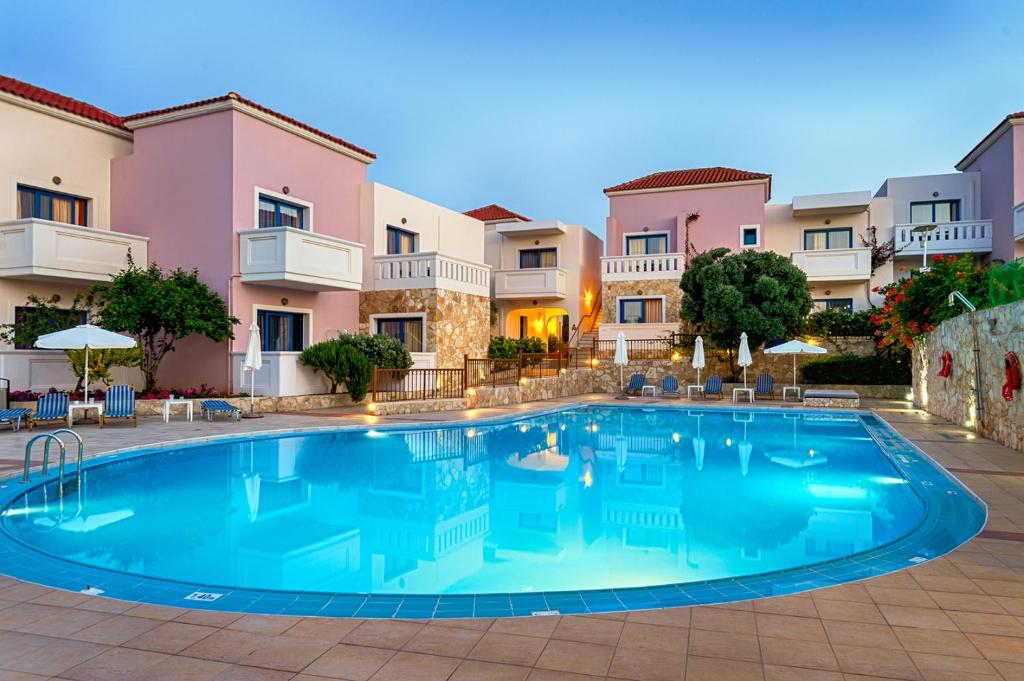 uma piscina em frente a alguns edifícios de apartamentos em Adelais Hotel em Tavronitis