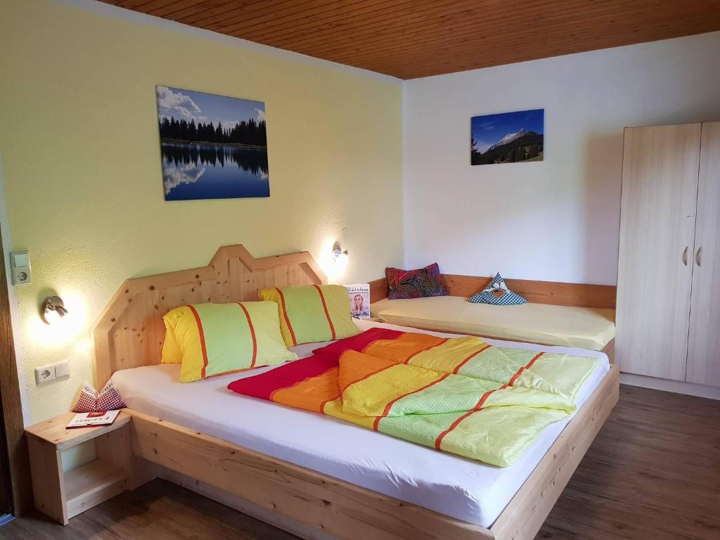 sypialnia z 2 łóżkami i kolorowymi kocami w obiekcie Haus Margret w mieście Stummerberg