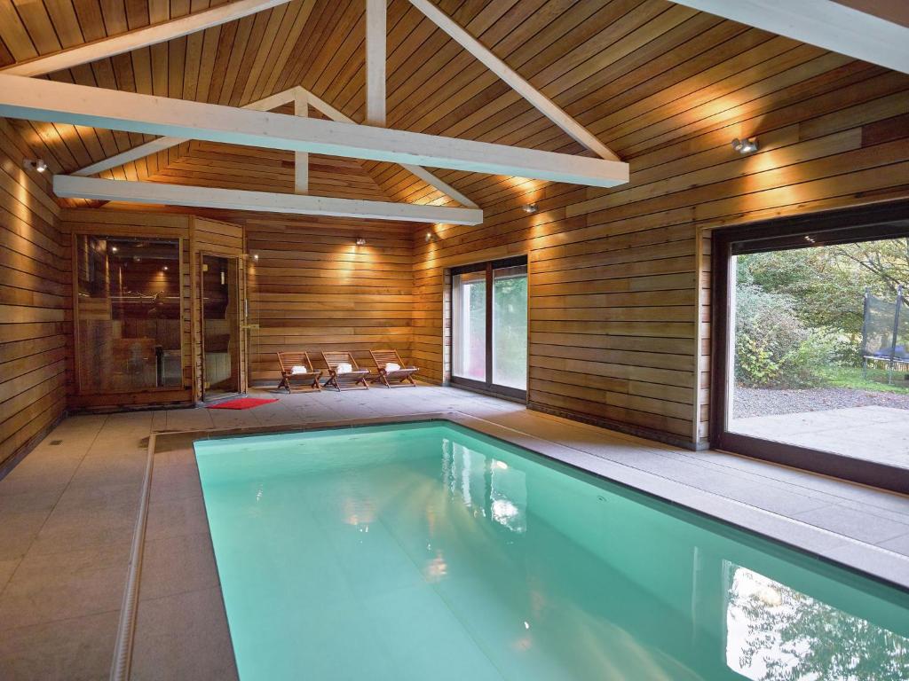 ストゥモンにあるLuxurious villa in Stoumont with saunaの木の壁の家の屋内プール
