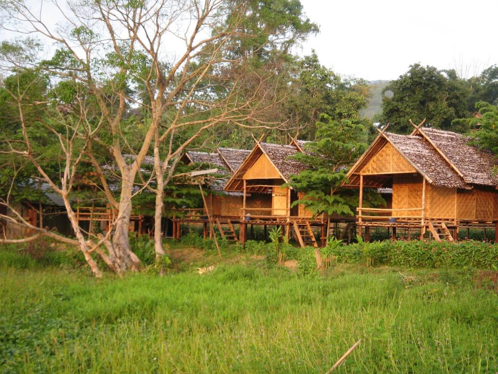 a group of wooden huts in a forest at Twin Hut in Pai