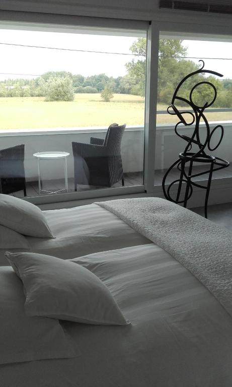ein weißes Schlafzimmer mit einem Bett und einem großen Fenster in der Unterkunft B&B Het Museum in Berlaar