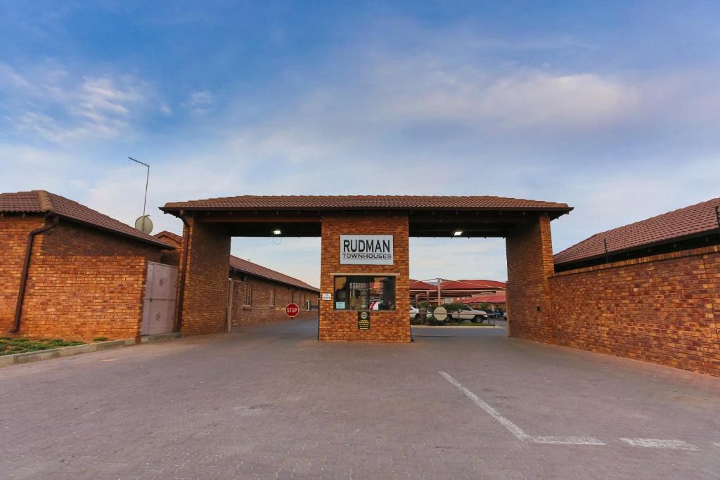 a brick building with a donation sign in a parking lot at Rudman Townhouses Self-catering Accommodation in Boksburg