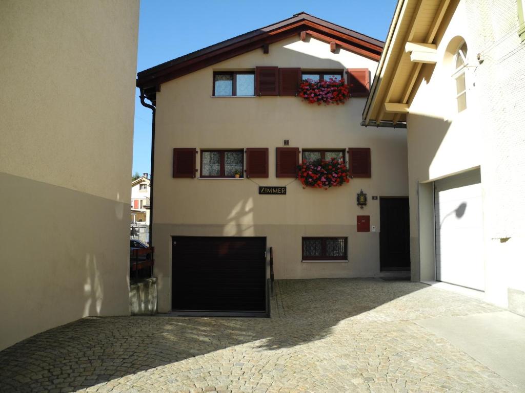 a building with two windows and a courtyard at Privatzimmer / bed & breakfast in Andermatt