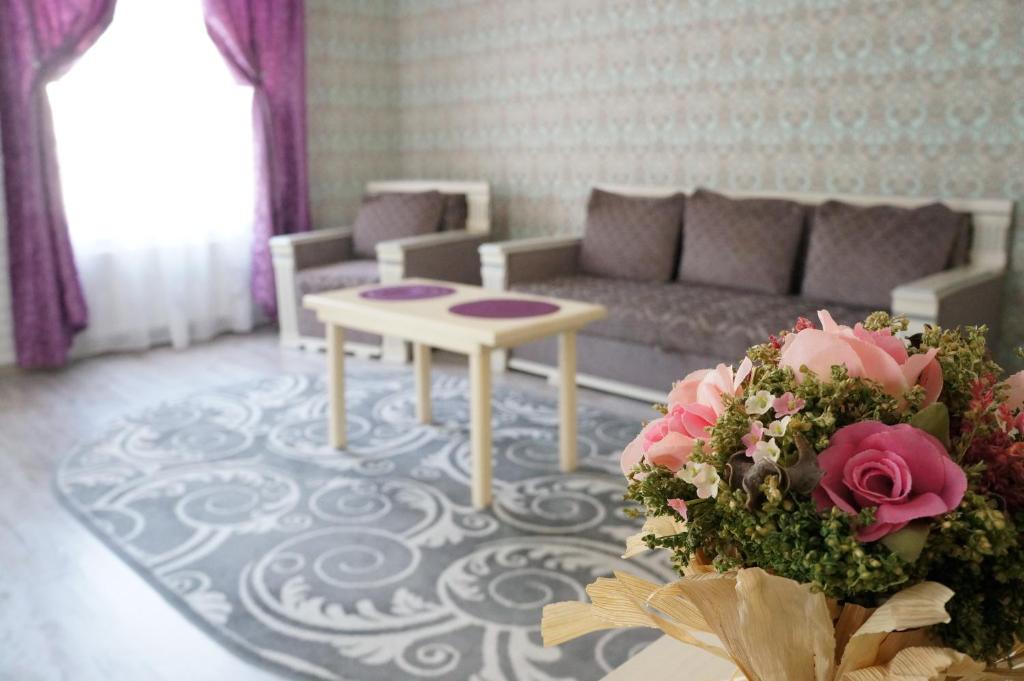 リヴィウにあるApartment Glebovaのリビングルーム(ソファ、花のテーブル付)