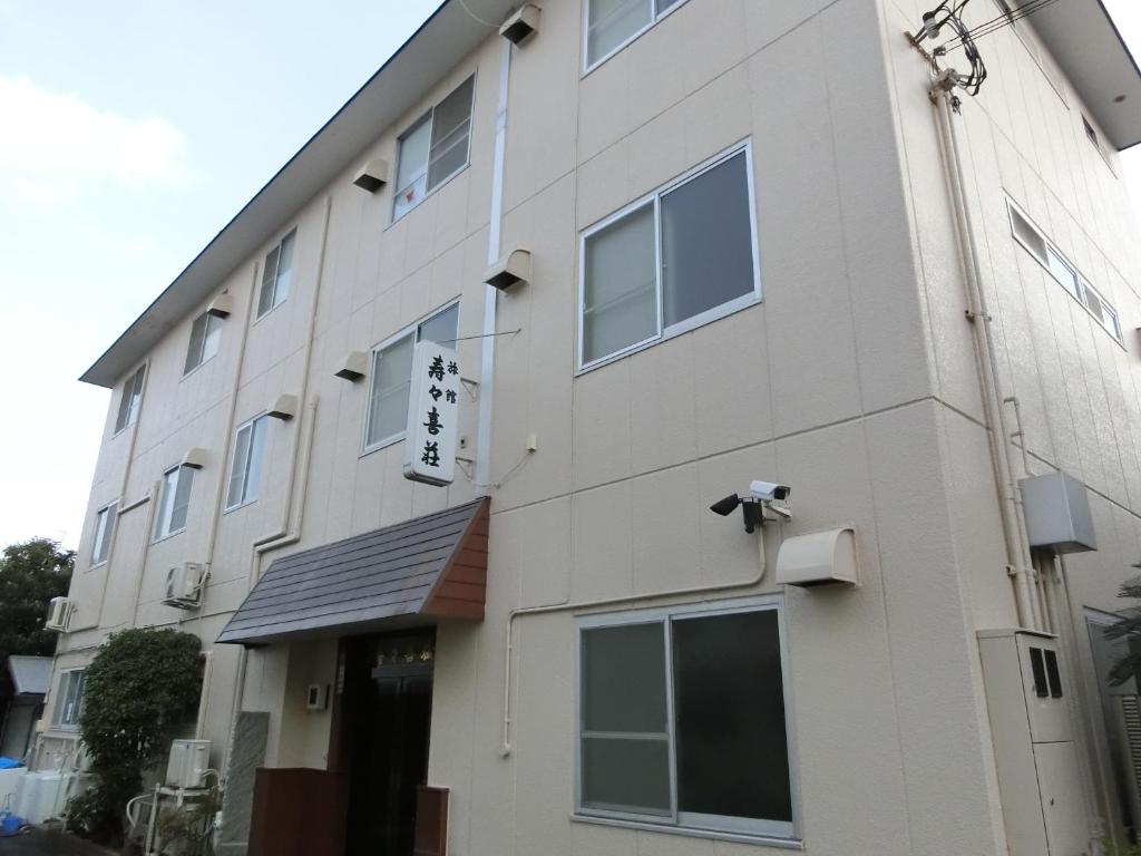 un edificio blanco con un cartel en el costado en Suzukisou, en Kioto