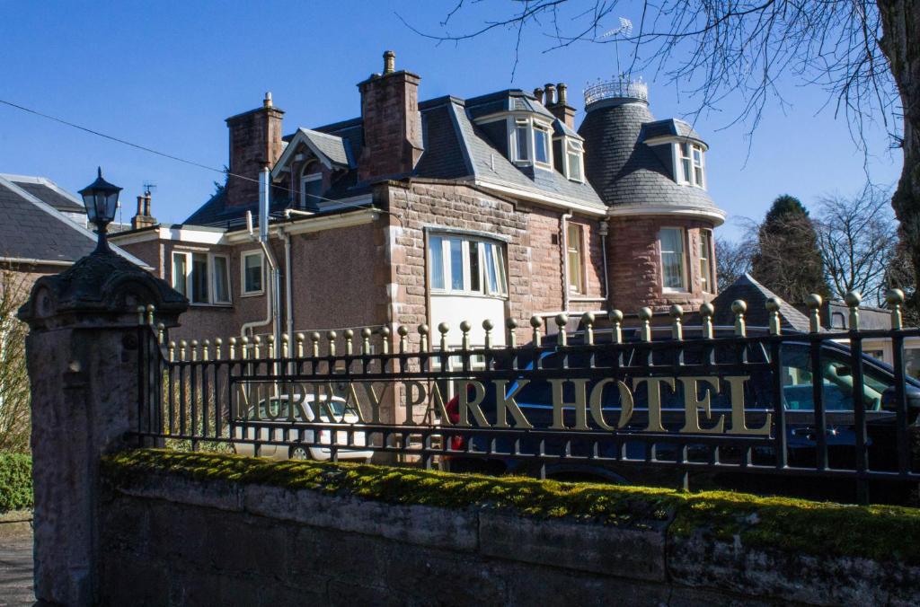 a large house with a black wrought iron fence at The Murray Park Hotel in Crieff