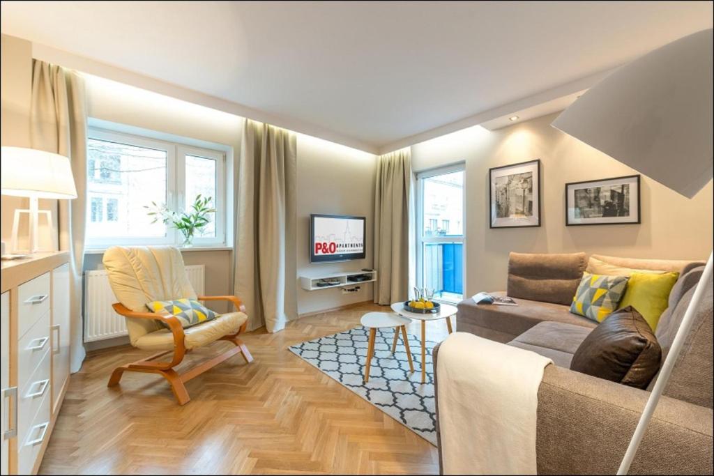 a living room with a couch and a tv at Chmielna Warsaw Cental Station P&O Serviced Apartments in Warsaw