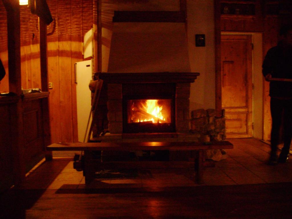 a fireplace in a room with a person standing next to it at Pension nad Truhlárnou in Svoboda nad Úpou