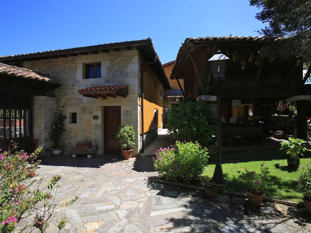 una casa de piedra con un jardín delante de ella en La Casina de la Arquera, en Llanes