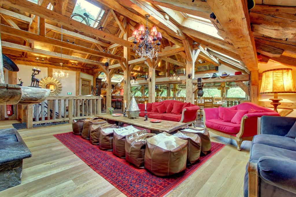 una gran sala de estar con muebles de color rojo y una mesa. en La Ferme du Lac Vert, en Montriond