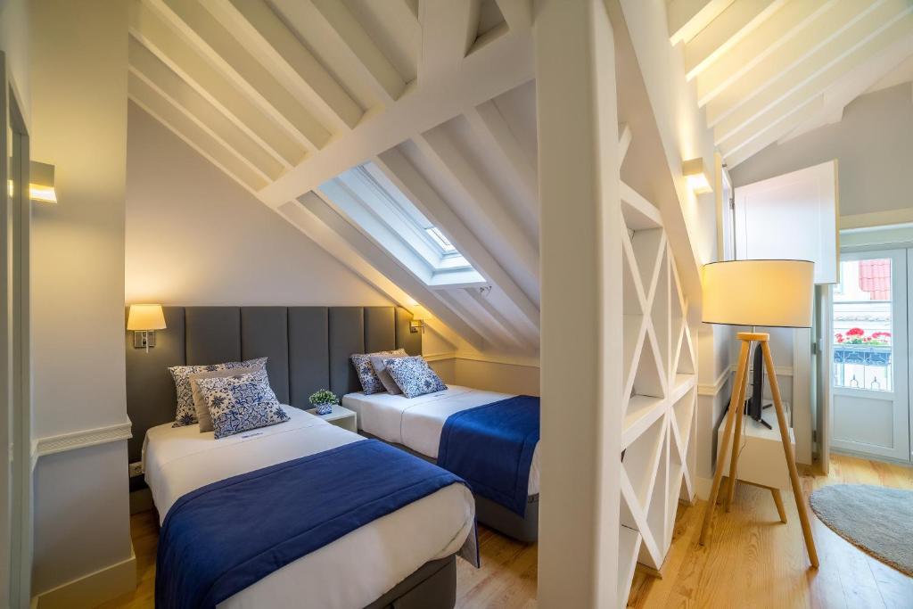 two beds in a room with a attic at Villa Baixa - Lisbon Luxury Apartments in Lisbon