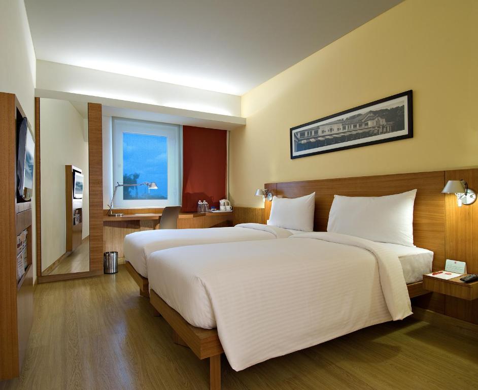 a bedroom with a large white bed and a window at ibis Pune Viman Nagar - An Accor Brand in Pune