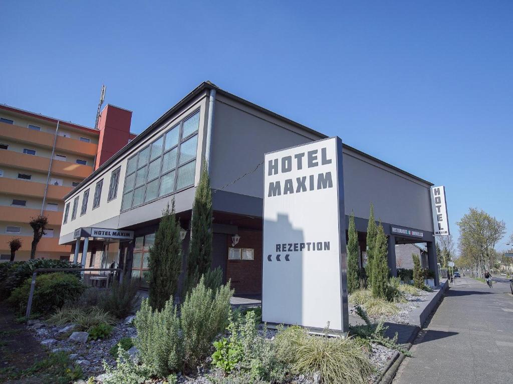 ein Gebäude mit einem Schild, das das Hotel maximal liest in der Unterkunft Hotel Maxim in Langenfeld