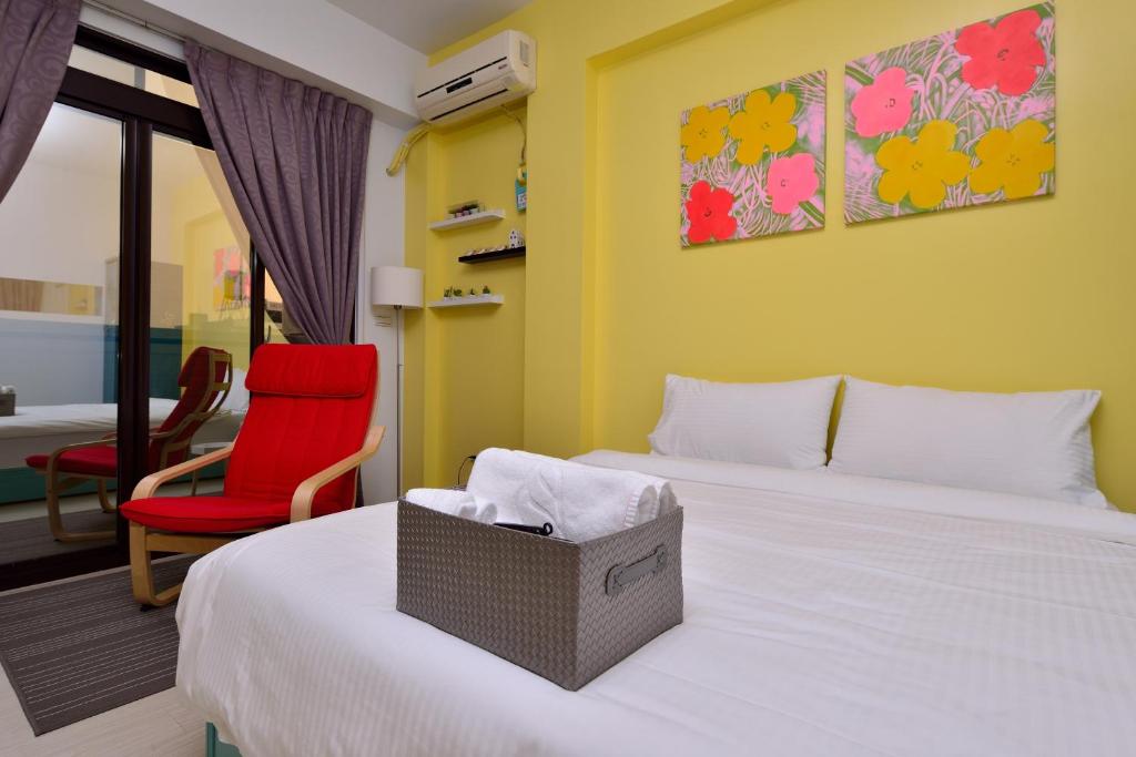 a bedroom with a bed and a red chair at STSP Guest House in Xinshi