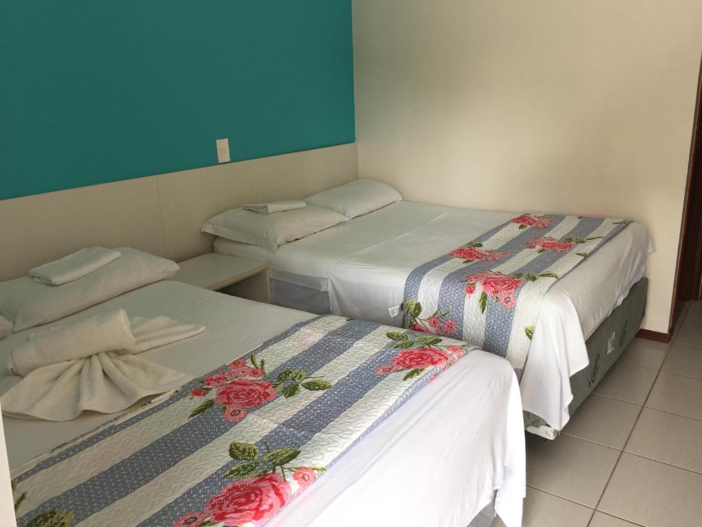 Nannai Térreo Porto de Galinhas 06 في بورتو دي غالينهاس: غرفة بسريرين عليها ورد