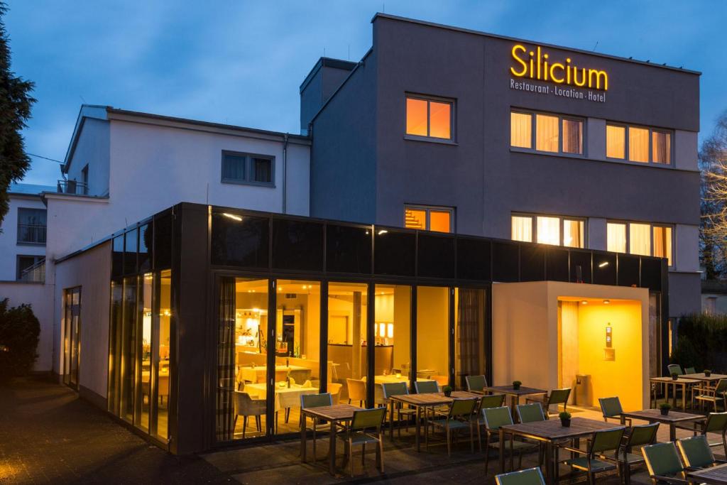 ヘール・グレンツハウゼンにあるHotel Siliciumの目の前にテーブルと椅子が置かれた建物