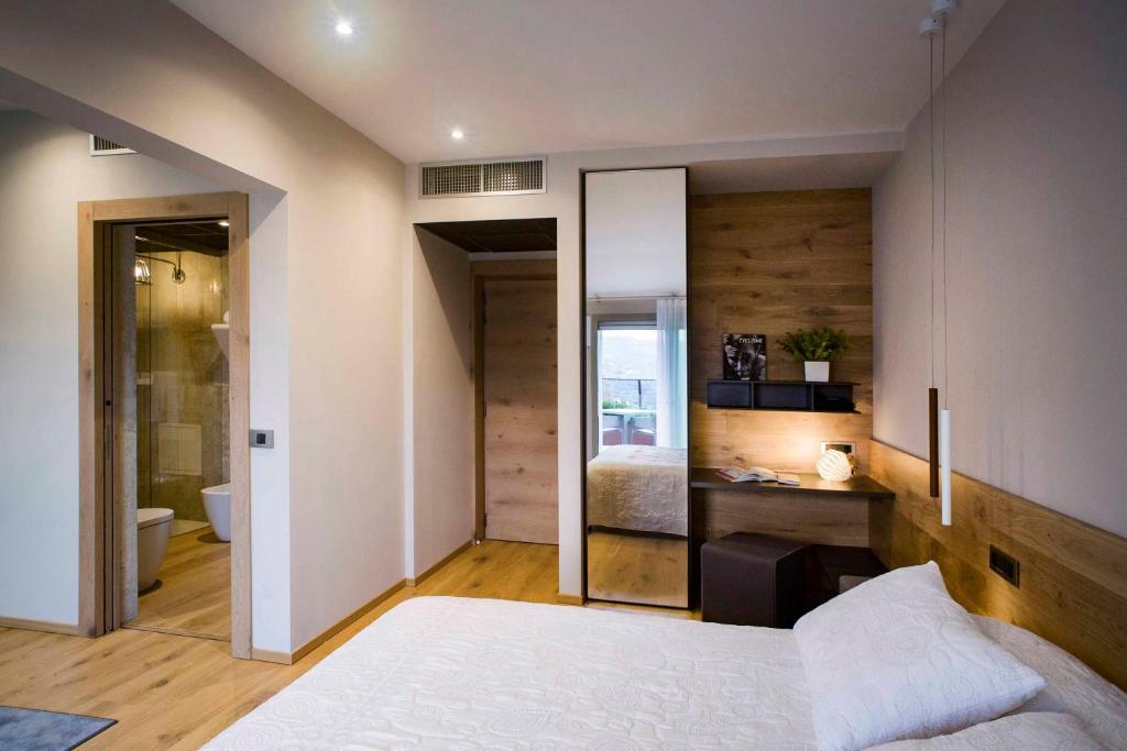 a bedroom with a white bed and a bathroom at Hotel Ristorante La Rosina in Marostica