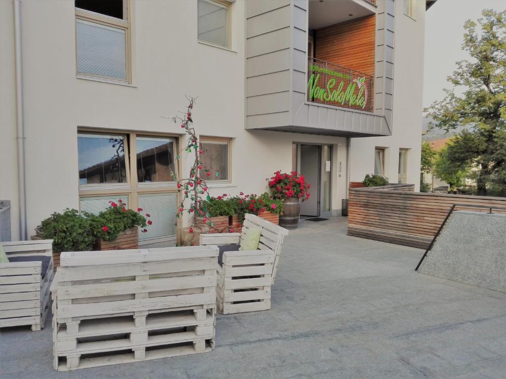 une rangée de chaises blanches à l'extérieur d'un bâtiment dans l'établissement NonSoloMele, à Romallo