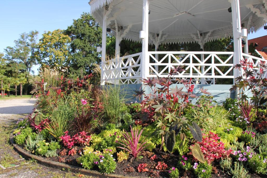- un jardin fleuri devant un kiosque blanc dans l'établissement Le Charme des Dunes, à Arcachon