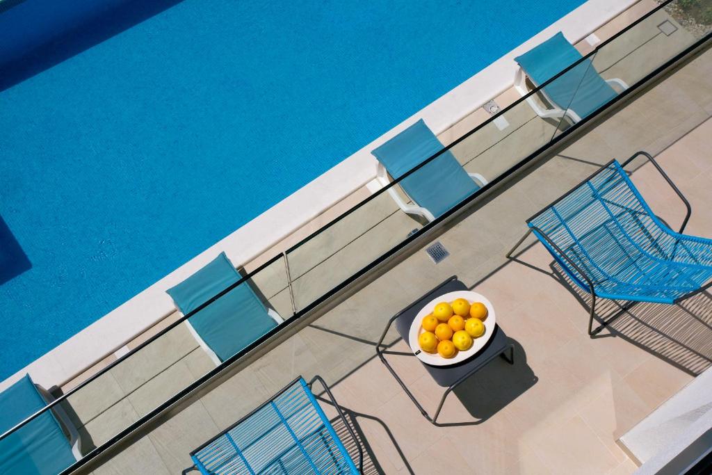 an overhead view of a bowl of oranges next to a pool at Villa Elena in Podstrana