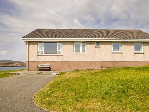 a house with a bench in front of it at 7 Habost in Balallan