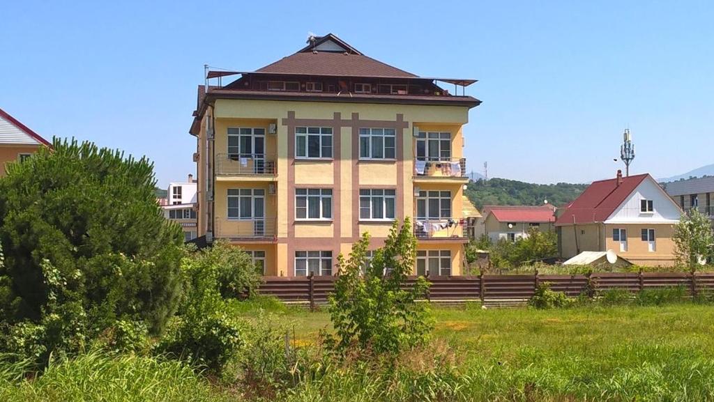 アドレルにあるApartment on Kamyshovoi 6の草原の大きな黄色の建物